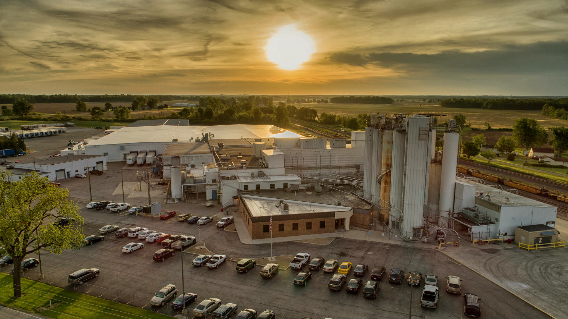 Sun sets in sky behind bakery mix plant