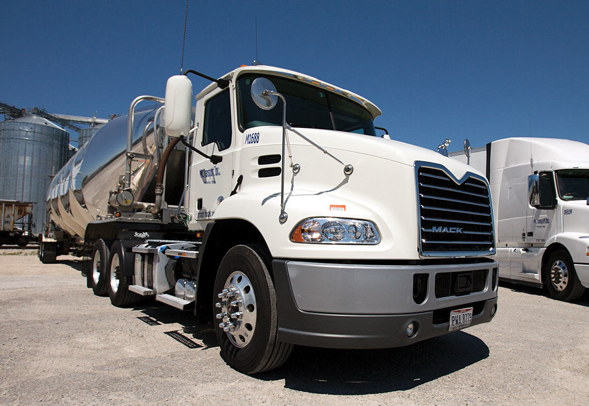 Front end of a MMC semi truck parked in a stone lot
